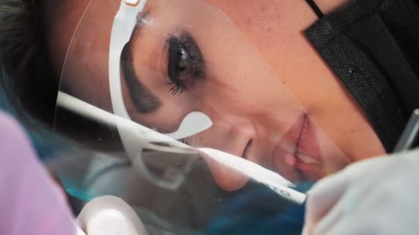 Vacker Kvinna Tandläkare Ett Skyddande Sköld Och Ansiktsmask Med Hjälp — Stockvideo