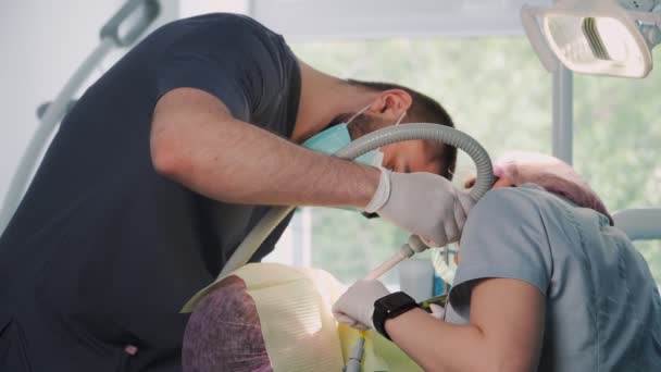 Jonge Vrouwelijke Tandarts Met Mannelijke Assistent Onderzoeken Werken Aan Patiënten — Stockvideo