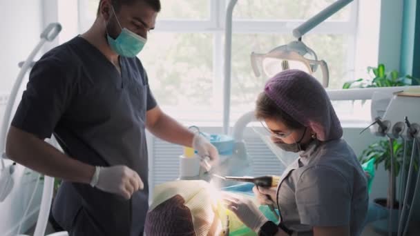 Erkek Asistanı Ile Genç Dişçi Hasta Dişleri Nceleme Üzerinde Çalışıyor — Stok video