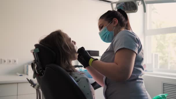 Mujer Joven Dentista Examina Paciente Consulta Dental Odontología Cepillarse Cuidar — Vídeos de Stock