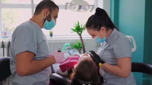 Два Врача Стоматолога Медицинских Масках Мужчина Женщина Стоматологическом Кабинете Проводят — стоковое видео