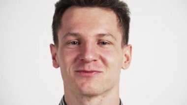 Genç adam beyaz arka planda gülüyor. Komik videolar Çok neşeli bir insan. Olumlu bir ruh hali..