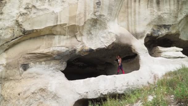 Mädchen geht durch Höhle. Höhlenstadt in der Nähe von Bachtschissarai - tope kermen auf der Krim — Stockvideo