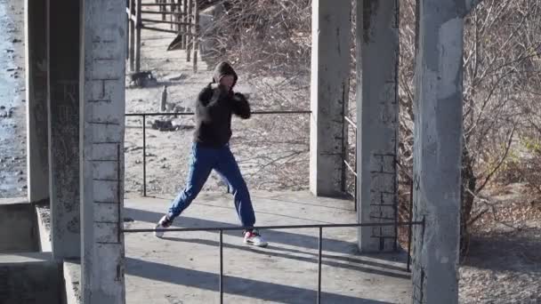 El boxeador se entrena en un edificio abandonado al aire libre. Ejercicio sombra Boxeo. — Vídeos de Stock