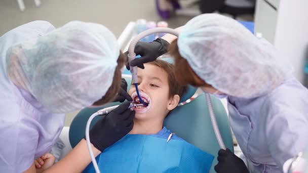 Dvě ženy Lékaři v lékařském čepici v zubní klinice, Sloužit Pacient Little Boy — Stock video