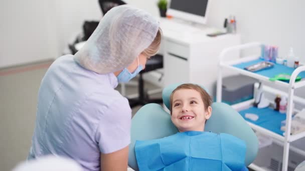 Médecin en clinique dentaire Parler avec drôle petit garçon travail dentiste avec des enfants — Video