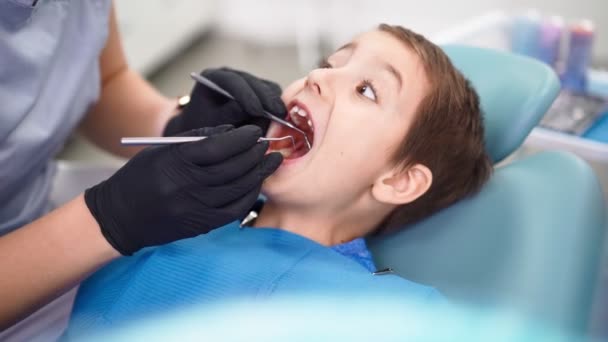 Femme Médecin en clinique dentaire, Servir Patient petit garçon avec des dents de bébé endommagées — Video