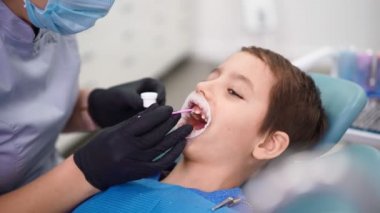 Diş Sağlığı Kliniğindeki Kadın Doktor Hasta Çocuk 'a Dişleri Hasarlı Çocuk Bakımı.