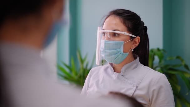 牙科诊所两名戴面具的女医生为女病人服务。工作牙医 — 图库视频影像