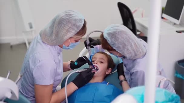 치과 병원의 두 여자 의사 가환자를 돕다 — 비디오