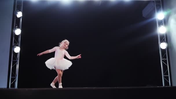 Niña bailarina de aspecto caucásico en un tutú rosa baila en el escenario. Niños. Movimiento lento. — Vídeos de Stock
