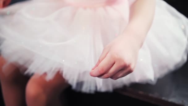 Красива маленька дівчинка-балерина в рожевому навчальному посібнику, сидить на сцені. Дитячий балет . — стокове відео