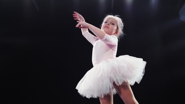 Niña bailarina de aspecto caucásico en un tutú rosa baila en el escenario. Niños. Movimiento lento. — Vídeos de Stock