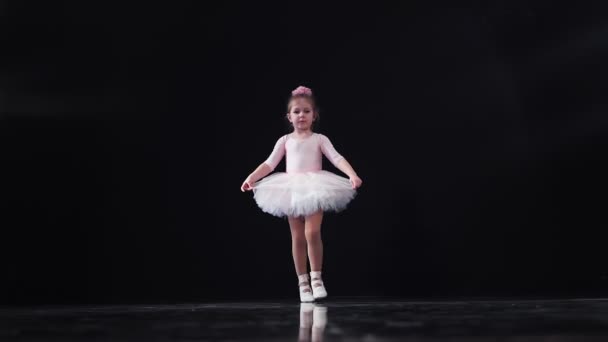 Liten flicka ballerina Kaukasiska utseende i en rosa tutu danser på scenen. Barn. Långsamma rörelser. — Stockvideo