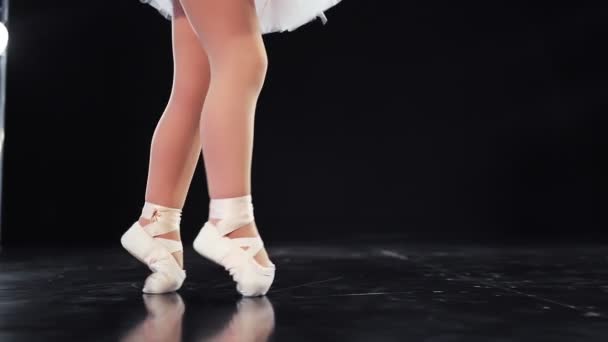 Mooie baby voeten in ballet flats ballerina 's kruisen het podium. Een close-up. Langzame beweging. — Stockvideo