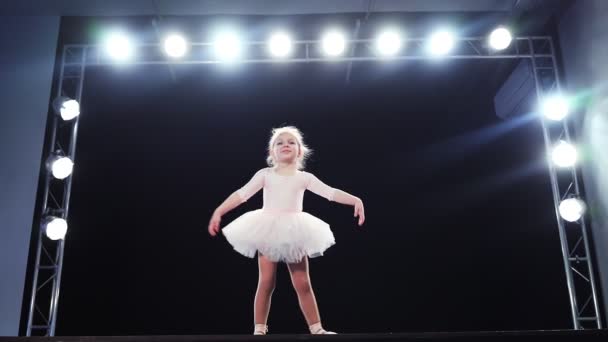 Bambina ballerina aspetto caucasico in un tutù rosa balla sul palco. Bambini. Rallentatore. — Video Stock