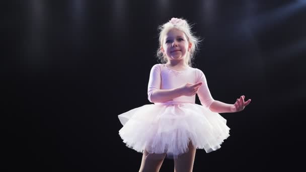 Liten flicka ballerina Kaukasiska utseende i en rosa tutu danser på scenen. Barn. Långsamma rörelser. — Stockvideo
