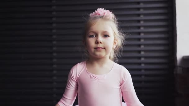 Kinderballerina in rosa Tutu kavkazskoi sieht blond aus. Steht am Fenster und lächelt. Zeitlupe — Stockvideo