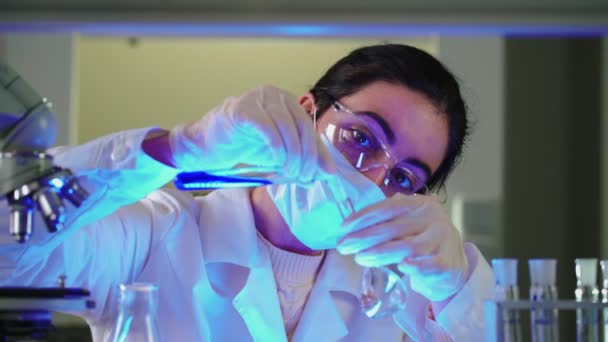 Scienziato in laboratorio che fa esperimenti chimici con liquido blu in provette — Video Stock