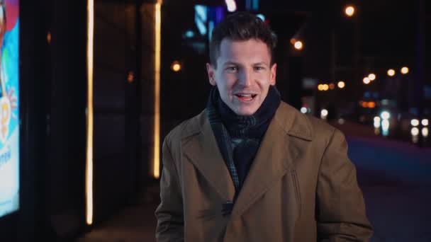 寒い冬の夜に輝くショッピングセンターの近くを歩く面白い喜びの男 — ストック動画