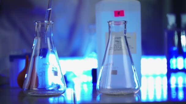 Ilmuwan di laboratorium melakukan percobaan kimia dengan cairan dalam tabung dan termos — Stok Video