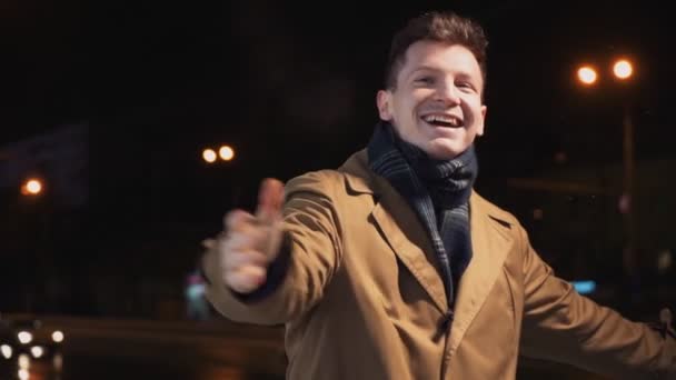 Gelukkig glimlachen succesvolle man wervelt en danst vreugde en geluk op de winternacht — Stockvideo