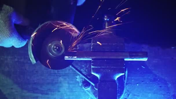 Professional mechanic cuts off metal pipe with a grinder, clamping them in vise — Stock Video