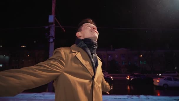 Onnellinen hymyilevä menestyvä mies pyörii ja tanssii iloa ja onnea talviyönä — kuvapankkivideo