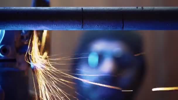 Mecánico profesional corta tubo de metal con una amoladora, sujetándolos en vise — Vídeo de stock