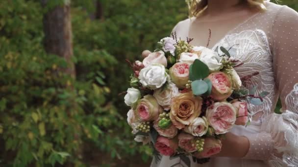 Mujer novia en vestido de novia tiene hermosas rosas ramo de diferentes colores — Vídeos de Stock