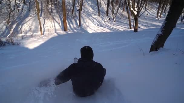 Happy Man monta um trenó de um monte de neve. Guy está se divertindo em uma floresta de inverno. — Vídeo de Stock