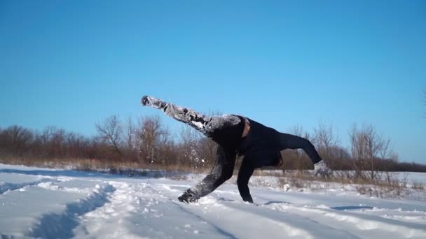 Парень бежит в снегу и делает крутой трюк с сальто в Сноудрифте. Человек веселится — стоковое видео