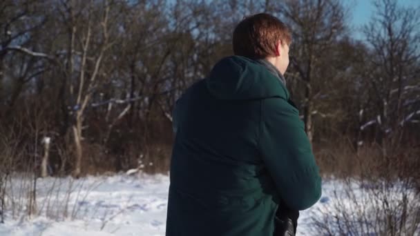 Milenci stojí a objímají se v Zimním lese. Krásný muž a žena v objetí — Stock video