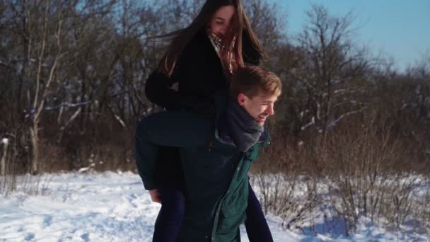 Šťastný pár Baví v Zimním lese. Roztomilý úsměv chlap s přítelkyní hrát