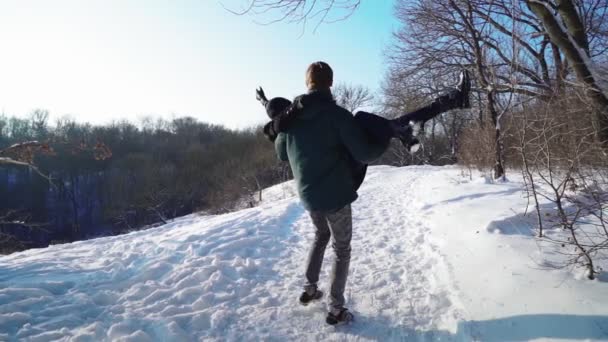แฮปปี้ คู่รัก ใช้เวลาอย่างสนุกสนานในป่าฤดูหนาว เล่นและโยนหิมะ . — วีดีโอสต็อก