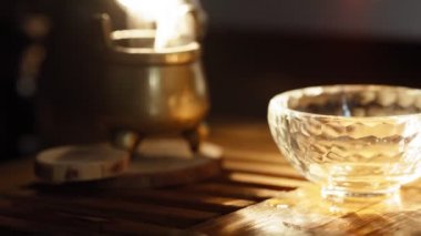 Çay, cam arka plana döküldü. Duman kokulu çubuklar, sıcak ışıkla aydınlatılıyor.