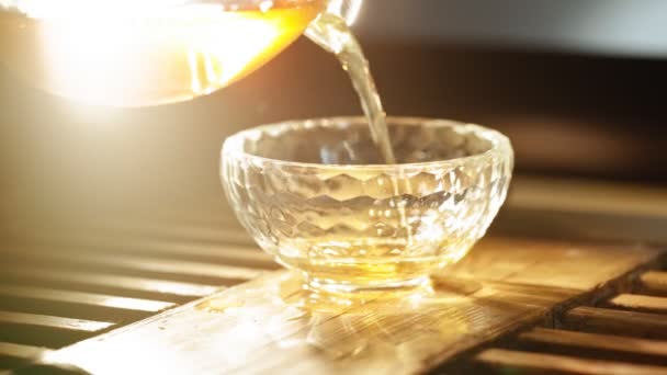 茶倒入玻璃杯背景烟熏香棒，背对着温暖的光线 — 图库视频影像