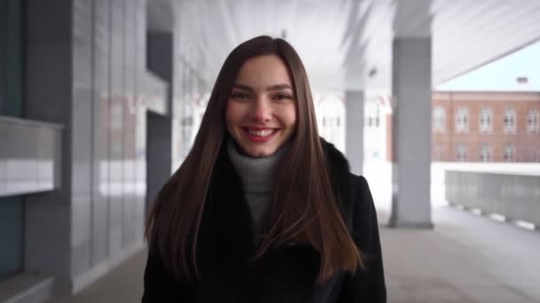 Mooie glimlachende vrouw met mooie glimlach wandelingen langs City Street. Langzame beweging — Stockvideo