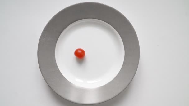 Чоловік на дієті їсть дуже мало помідорів чилі та огіркової тарілки. Концепція схуднення — стокове відео