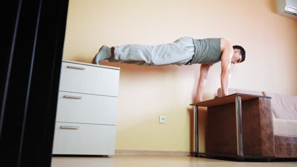 Μυϊκός αθλητικός άνδρας κάνει push-up άσκηση στο σπίτι κλίνει στο κρεβάτι. — Αρχείο Βίντεο