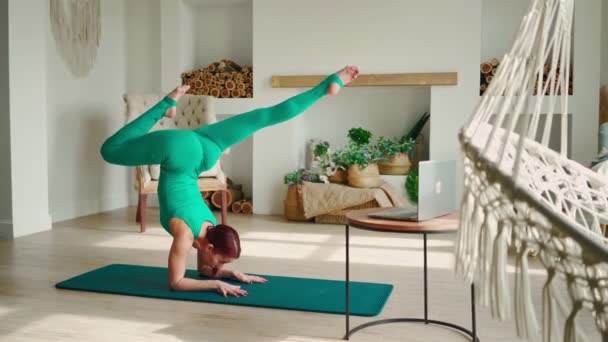 Wanita Atletik melakukan Handstand dengan Bantuan Instruktornya Online di Laptop. Yoga — Stok Video