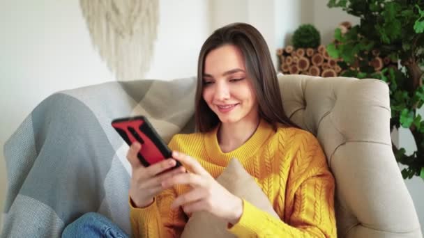 Žena Usmívající se Hold Smartphone Sledování sociálních médií Příběhy Video Sit on Sofa — Stock video