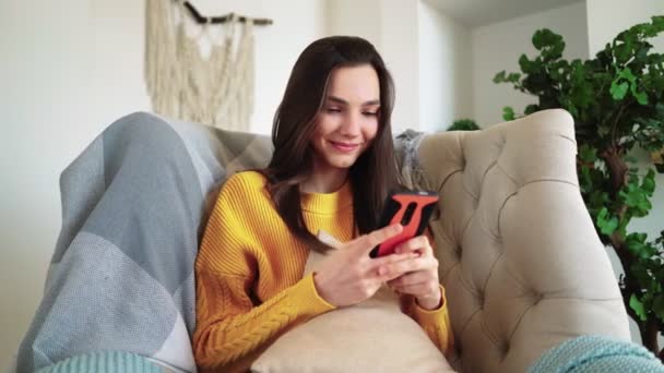 Žena Usmívající se Hold Smartphone Sledování sociálních médií Příběhy Video Sit on Sofa — Stock video