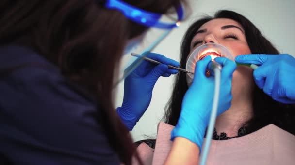 Dentista professionista donna in guanti medici esamina paziente in clinica dentale — Video Stock