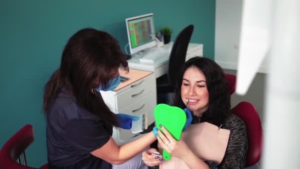 Femme dentiste montre les dents dans le miroir après brossage patient en clinique dentaire — Video