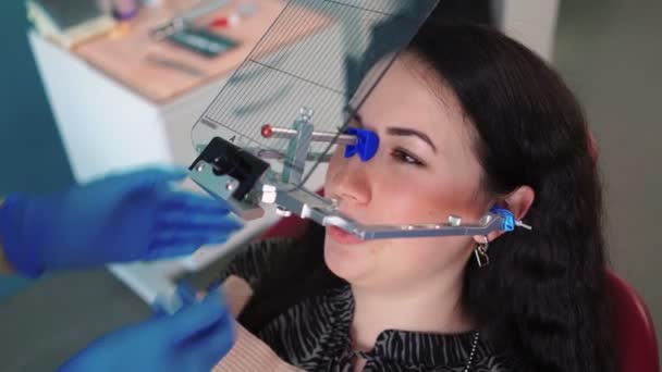 Стоматолог в медицинских перчатках с помощью специального инструмента обследования пациента в стоматологической клинике — стоковое видео