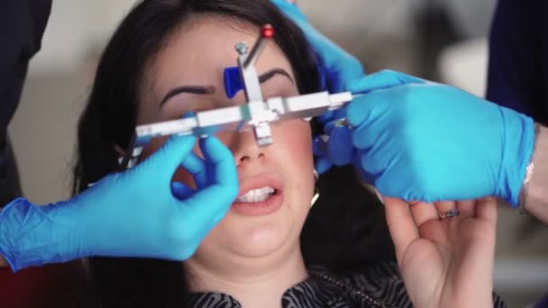 Dentista in guanti medici utilizzando strumenti speciali esamina paziente in clinica dentale — Video Stock