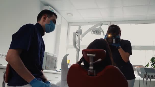 Ärztin mit Kamera in der Hand fotografiert Patientin nach Behandlung — Stockvideo