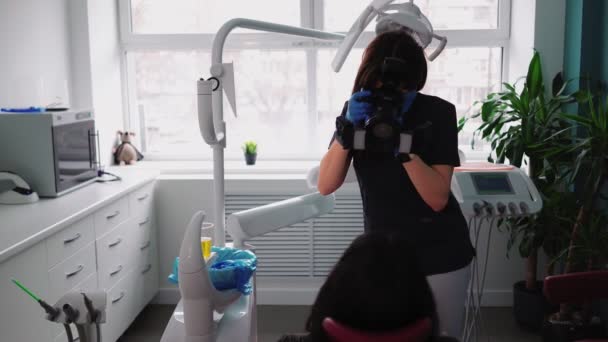 Mulher médico com câmera em suas mãos tira fotos paciente após o tratamento — Vídeo de Stock