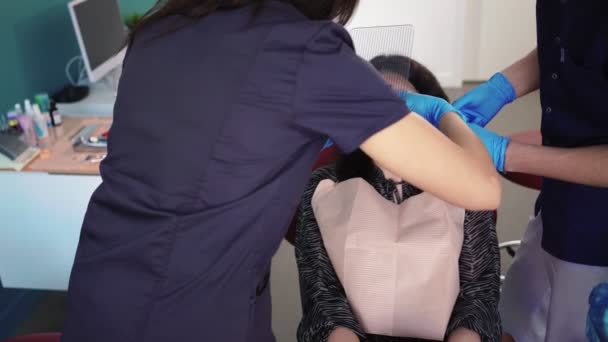 Dentiste dans les gants médicaux à l'aide d'un outil spécial Examine le patient dans une clinique dentaire — Video